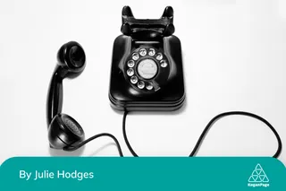 Black rotary dial phone on white surface