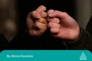 Two people fist-pumping, one fist adorned in several rings. To represent leadership in LGBTQ inclusion at work