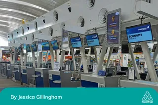 A row of electronic check in counters at an airport