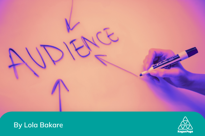 The word audience written on a board, a hand holding a marker having finished writing, and three arrows pointing to the word audience to indicate it's important in marketing with cultural literacy.