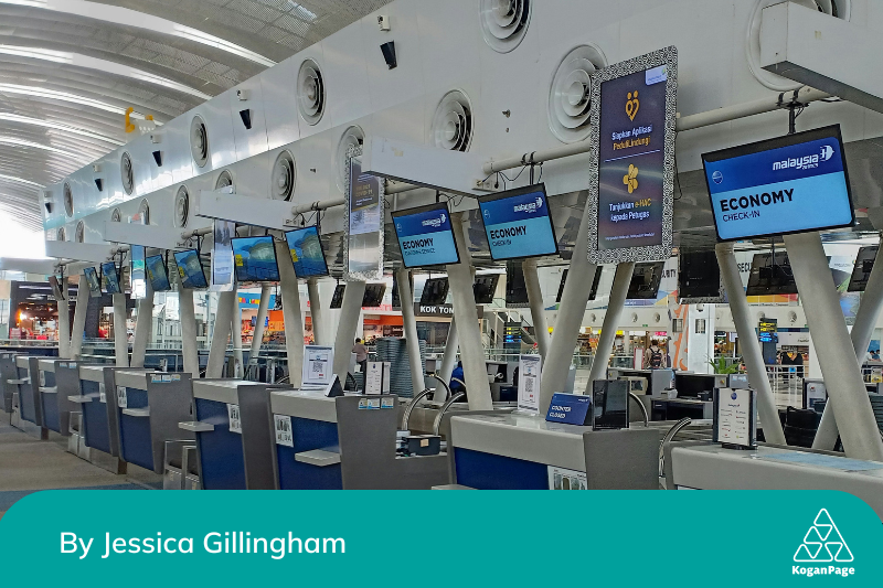 A row of electronic check in counters at an airport 