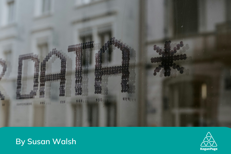 The word data on a window which is also reflecting the building in front of it.