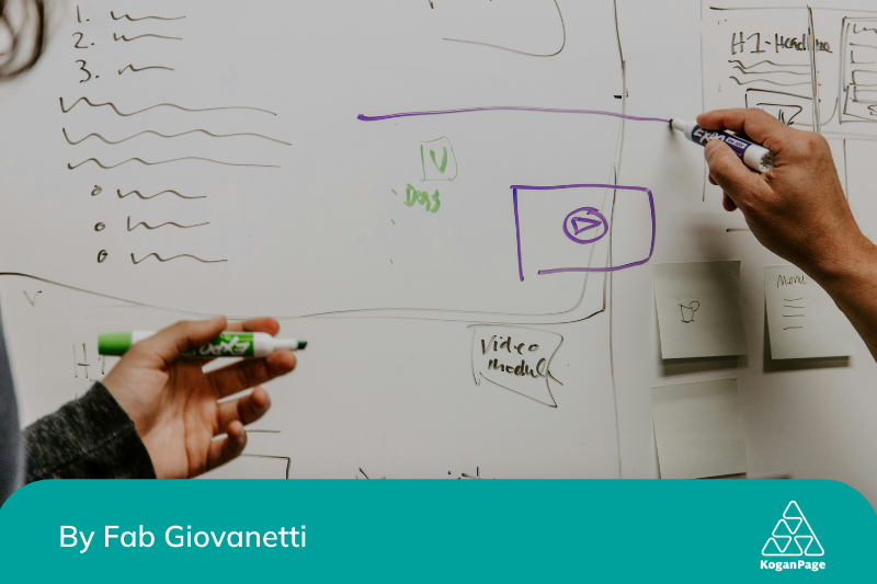 Two people drawing on a whiteboard