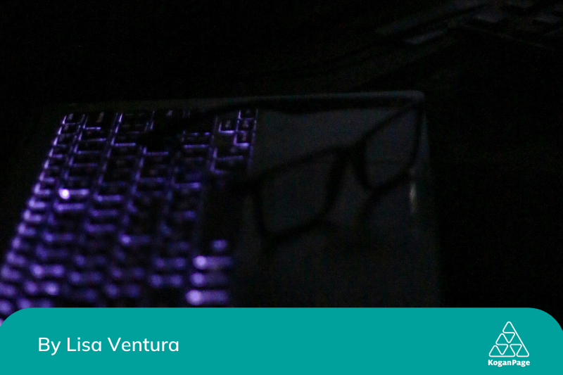 A computer keyboard lit-up in the dark.